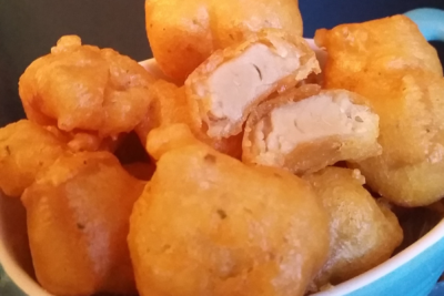a close-up of crunchy breaded vegan chicken showing the tender inside of one cut in half