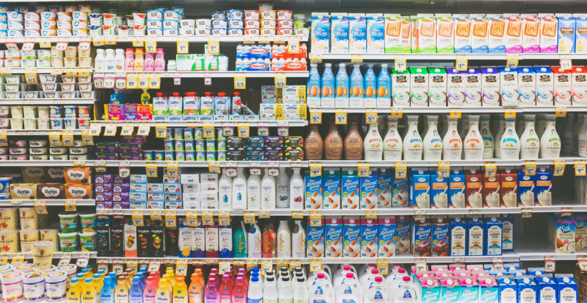 A selection of dairy and non-dairy products in a supermarket fridge. Often people can be left wondering "Is it vegan?" when reading food labels.