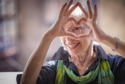 Cute senior woman making a heart shape with her hands and fingers