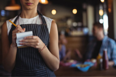 Unidentified waitress writing down an order in a restaurant