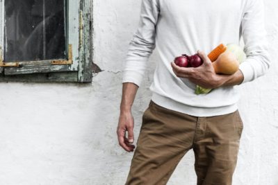 Person holding squash, corn, and apples