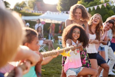 A group of adults and children playing tug of war 