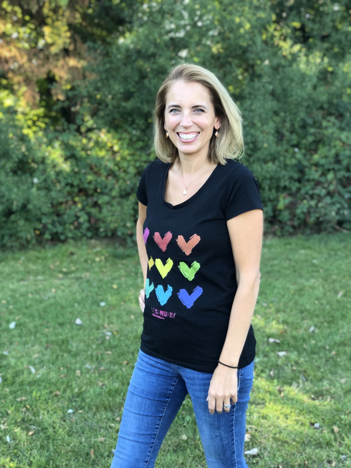 A woman, Jasmine, standing in field wearing Veganuary t-shirt. 