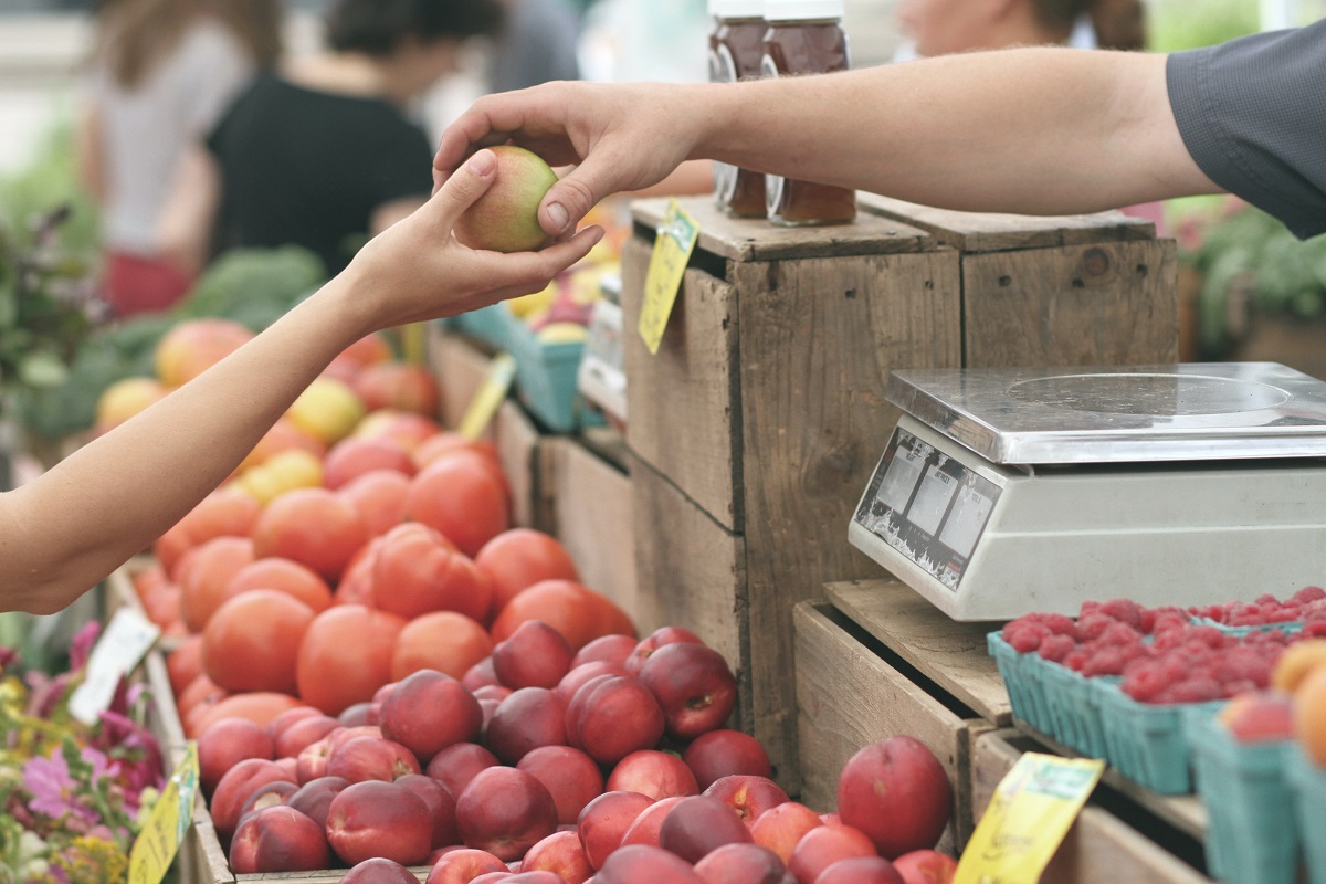 Unidentified person buying fruit from a local market
