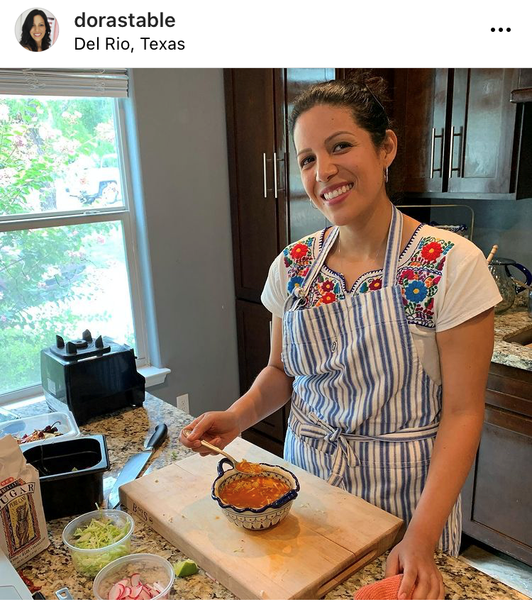 able in her kitchen with a bowl of soup and garnishes