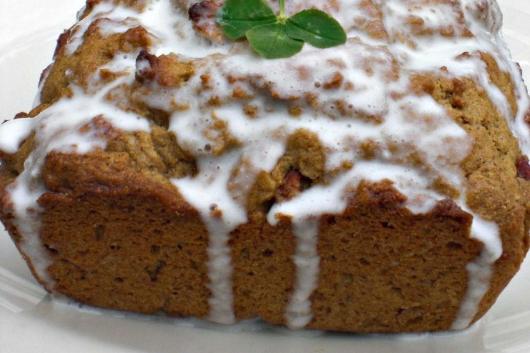 green tea almond cake dripping with a powdered sugar icing and decorated with a clover