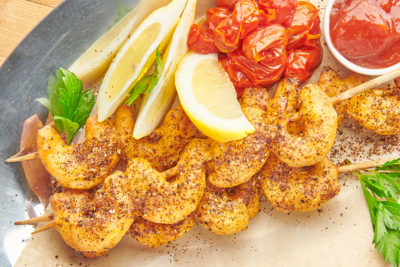 skewers of beer battered shrimp served with cocktail sauce and lemon