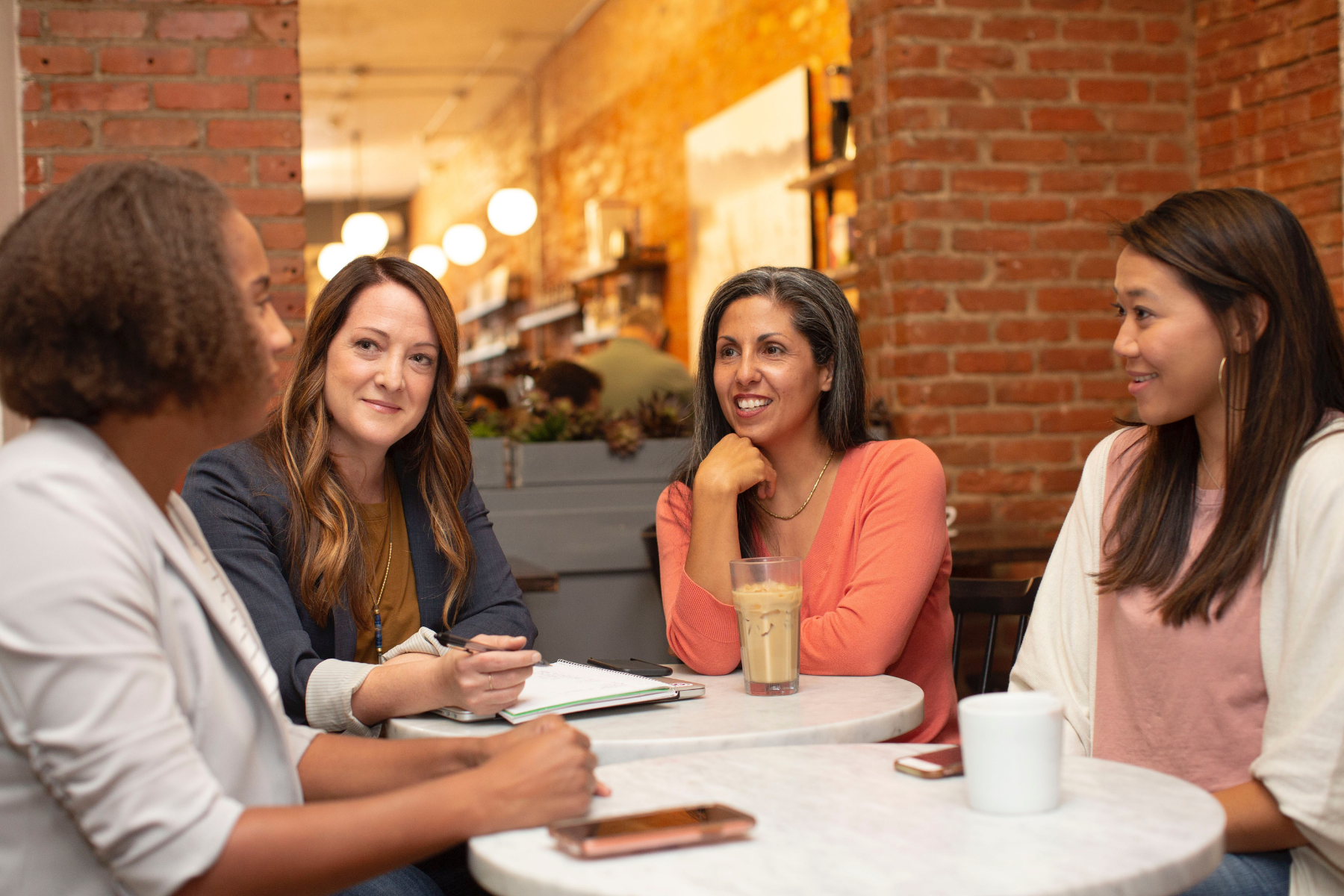Image shows four women of various ages and demographics smiling and talking about the benefits of going dairy-free