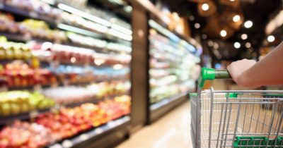 Person pushing shopping cart in a supermarket