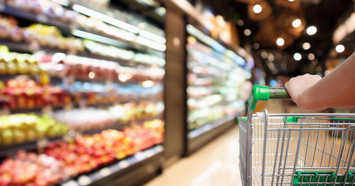 Person pushing shopping cart in a supermarket
