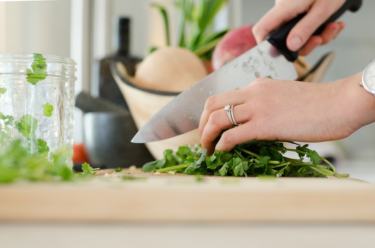Person preparing vegetables for vegan cooking in the kitchen
