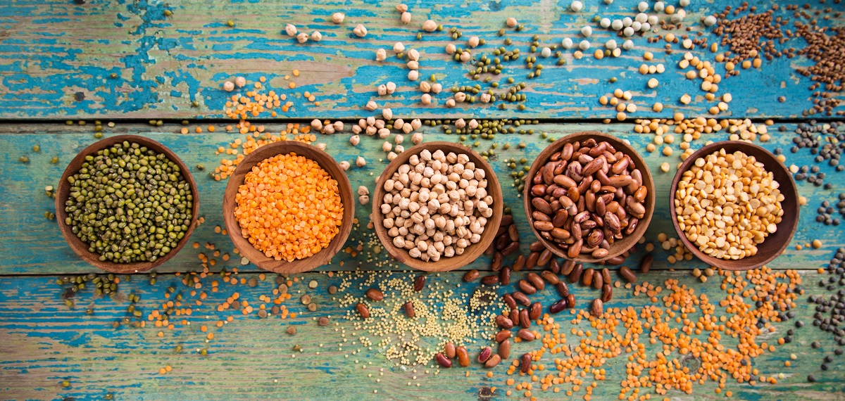 Raw legumes on old rustic wooden table.