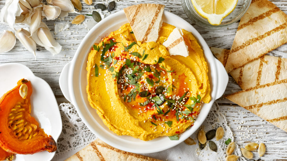Pumpkin hummus, creamy and delicious dip on a white plate, top view