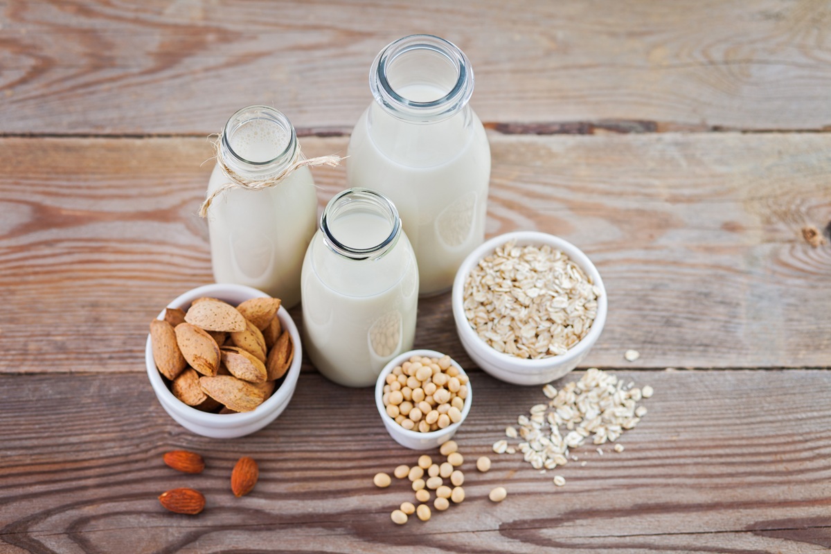 A selection of plant milks on a wooden table