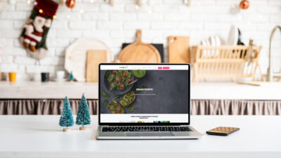 Laptop mit Rezeptseite in weihnachtlicher Küche